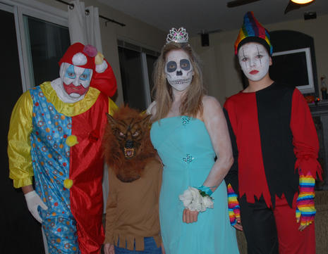 Four people posing in Halloween costumes